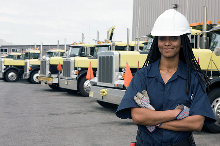 Woman Standing in Front of Fleet of Trucks